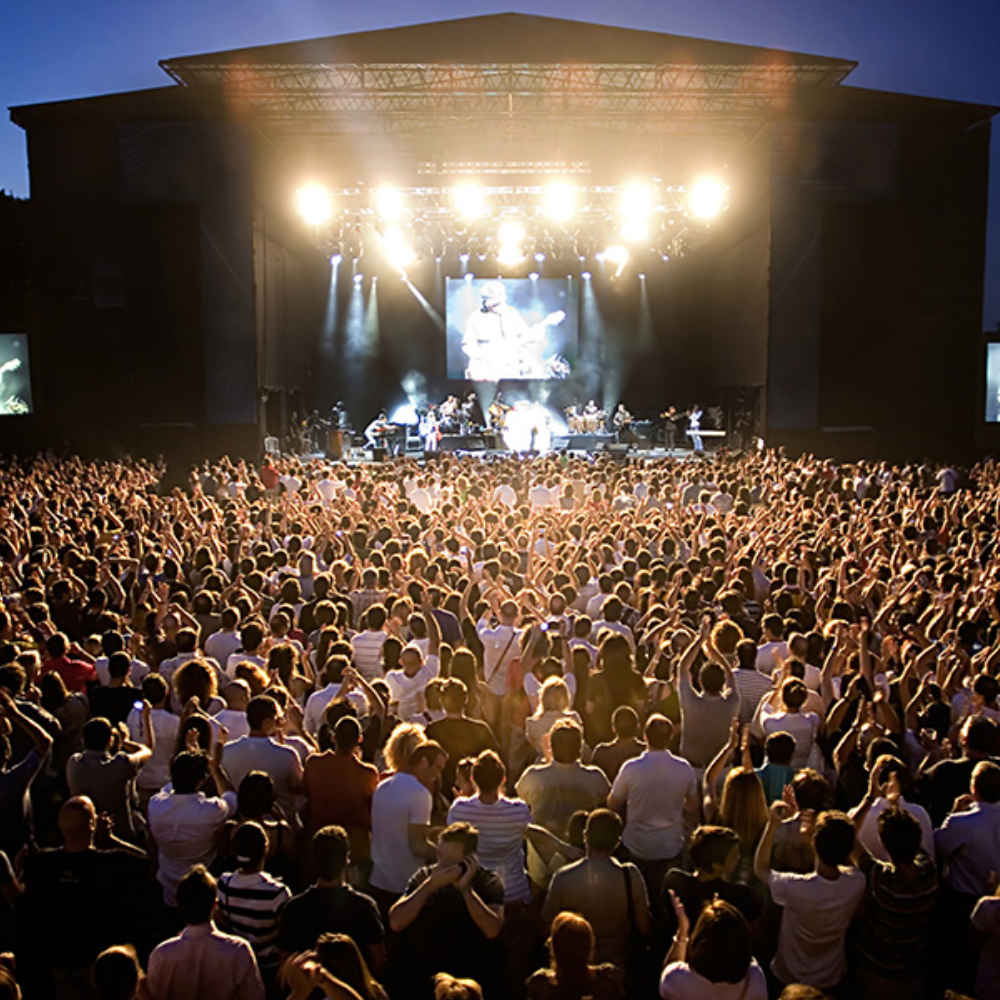 Large outdoor concert with a crowd and stage lights.